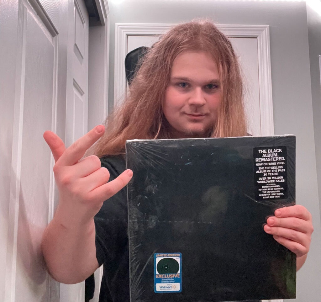 Lakes Region Community College student, Anthony DeBlois, holds a copy of a Metallica record.