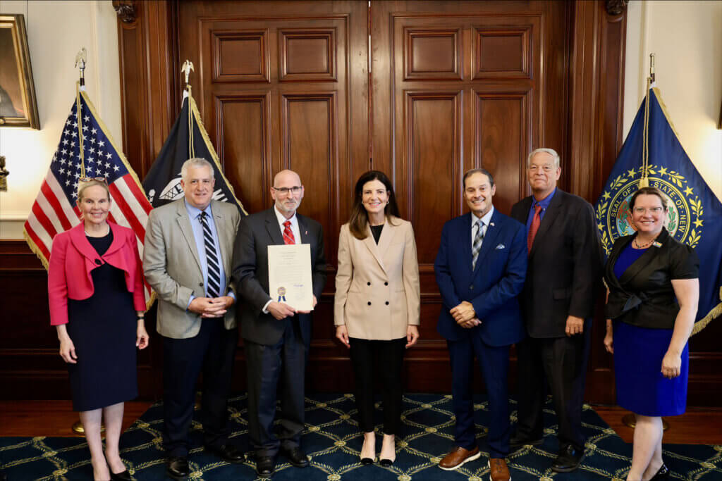 a group of people holding a commendation and smiling for the camera